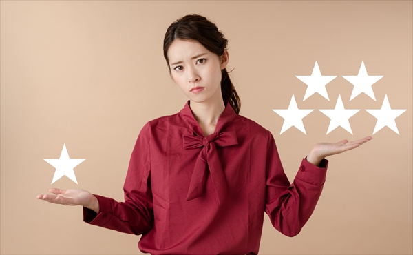 1つ星と5つ星を両手に持つ女性