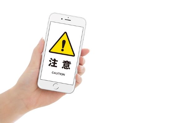 注意マークが表示されたスマホ