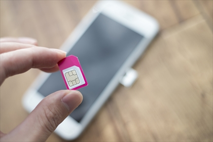 白いスマートフォンとピンク色のSIMカード