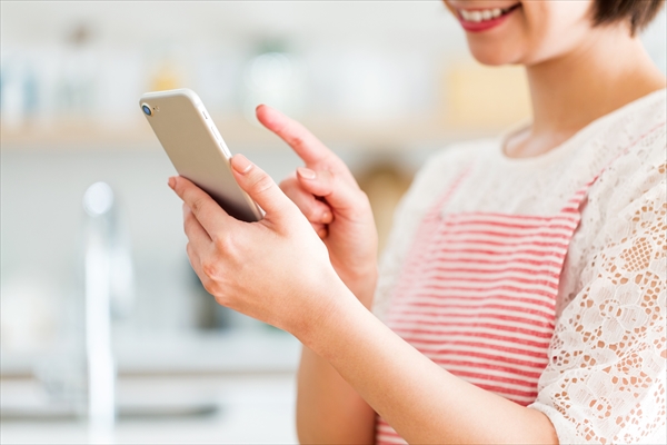 スマホを操作する女性の画像