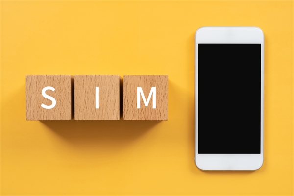 SIMと書かれたブロックと白いスマートフォン