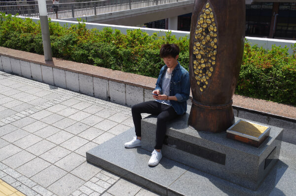 リアルすぎる納豆オブジェの横で黙々と携帯をいじっている、この人は…?