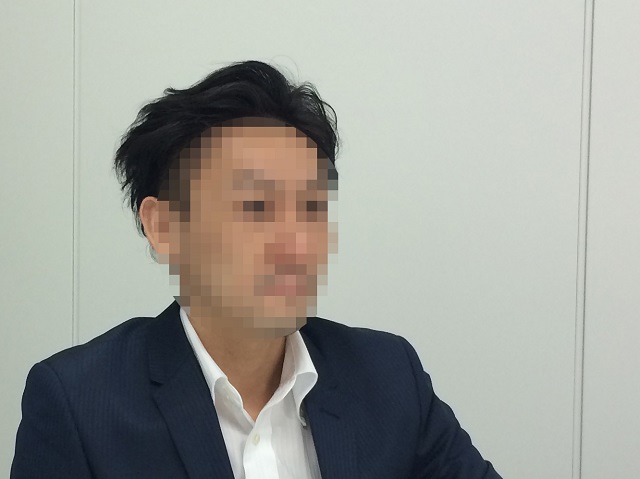 インタビューに応じるSIM人間のS氏