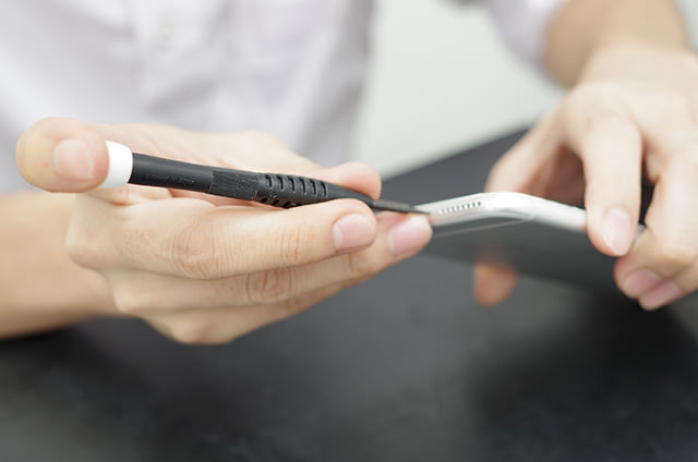 さっそく専用の工具で iPhone の修理に取り掛かる力さん