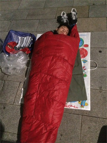 去年の就寝時の写真。アスファルトが硬くて痛いので気休めにマットを敷いています